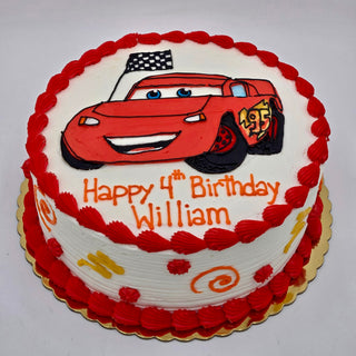 Round birthday cake with red and white icing, featuring a drawing of Lightning McQueen from Cars, a checkered flag, and the message Happy 4th Birthday William in orange letters.