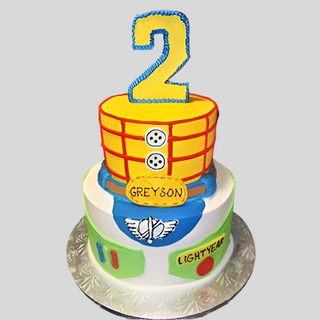 The Toy Story Tier is a two-tiered birthday cake inspired by Woody and Buzz Lightyear, topped with a large yellow number 2 and custom name on the front—an ideal personalized kids cake for any Toy Story fan!.