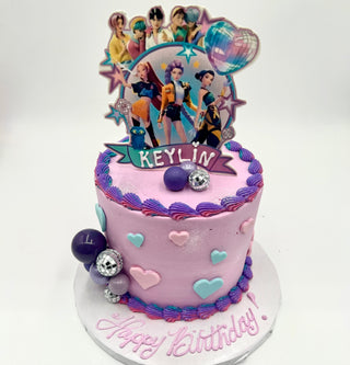 K-Pop Hearts: A pink and purple birthday cake decorated with hearts, spheres, animated character toppers, a disco ball, and "Keylin"—finished with "Happy Birthday" written in pink icing.