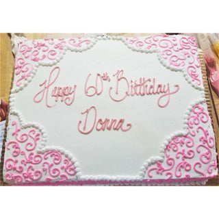 The Designed Corners rectangular white cake features pink and white decorative icing with "Happy 60th Birthday Donna" in pink cursive—ideal for those wanting specialty birthday cakes and custom cake designs.