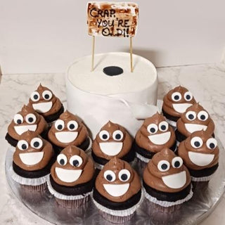The Poop Emojii custom birthday cake, shaped like a toilet paper roll with a "CRAP, YOU’RE OLD!" sign and surrounded by chocolate cupcakes topped with smiling Poop Emojii, is perfect for fun Specialty Birthday Designs.