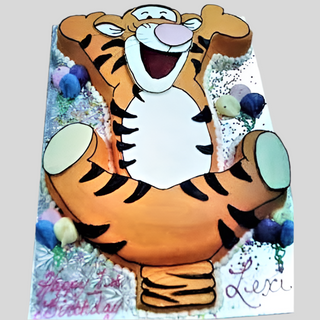The Tigger Body custom cake features Tigger’s playful shape with "Happy 1st Birthday Lexi" in icing, surrounded by colorful decorations and favorite kids’ characters.