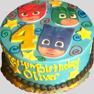 A blue custom PJ Masks Group cake decorated with yellow stars, colorful swirls, a big yellow number 4, and “Happy 4th Birthday Oliver” written in bright yellow icing.
