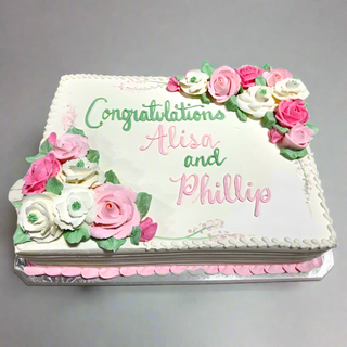 The Bridal Garden is a rectangular white custom cake adorned with pink and white icing roses, green leaves, and "Congratulations Alisa and Phillip" written in green and pink. Inspired by Bridal Garden elegance.