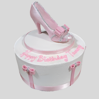 The Show Silhouette cake is a round white birthday creation with pink ribbon and bows, a fondant pink high-heeled shoe topper, and "Happy Birthday Tammy" in pink icing—ideal for Specialty Birthday Designs.