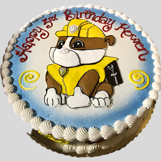 Rubble Drawn birthday cake: round with white icing, Rubble in yellow construction outfit, “Happy 3rd Birthday Rowen” in red. Yellow swirls on a blue background add a fun custom touch. Perfect for kids’ celebrations!.