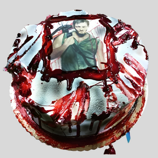 The Walking Dead Scan is a round custom cake with red "blood splatter" icing and an edible photo of a person holding a crossbow—perfect for fans and unique kids’ birthday celebrations.