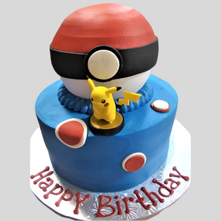 A kids' birthday cake decorated with a large Pokemon Ball and a Pikachu topper, featuring red, white, and blue accents. "Happy Birthday" is written in red on the silver cake board. Product: Pokemon Ball.