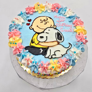 Charlie Hugs: Round cake with pastel blue, pink, and yellow icing, featuring a boy hugging a dog and "Happy Birthday Gracie!" written in pink icing.