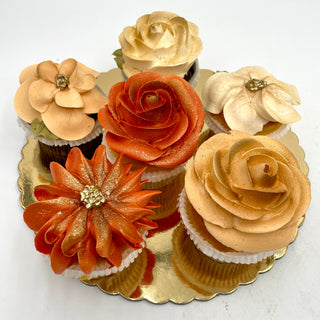 Autumn Cupcakes: Five elegantly decorated cupcakes with buttercream flowers in warm autumn shades of burnt orange, peach, and cream, finished with gold shimmer. Perfect for birthdays or custom orders.
