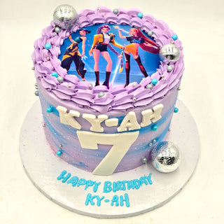 The K-Pop Party is a tall purple and blue birthday cake with silver balls, an edible topper of animated characters, large white KY-AH letters, a number 7, and "Happy Birthday KY-AH" written on the base.
