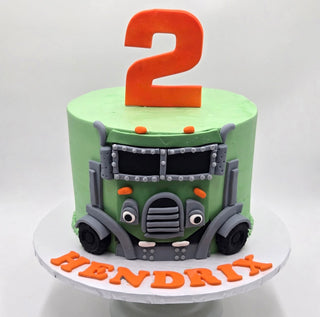 A green Trash Truck Fondant cake with a large orange number 2 on top and "Hendrix" in orange letters at the base.