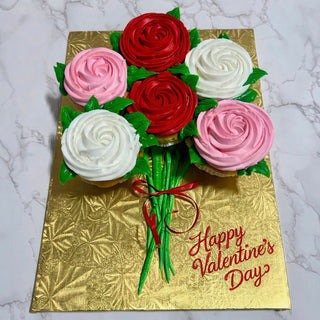 Valentines Roses: Cupcakes decorated as a bouquet of red, pink, and white roses with green stems and leaves on a gold board, featuring "Happy Valentines Day" in red icing.