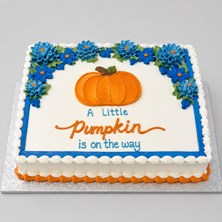 The Pumpkin Drawn is a rectangular custom cake with blue and green floral decorations, an orange pumpkin in the center, and "A Little Pumpkin is on the way" in orange and blue icing. Perfect for baby showers, it sits on a silver board.
