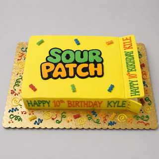 A rectangular birthday cake designed to resemble a yellow Sour Candy box, topped with colorful candies and "Happy 10th Birthday Kyle" written on the cake and side flap—a fun treat for any Sour Candy fan.
