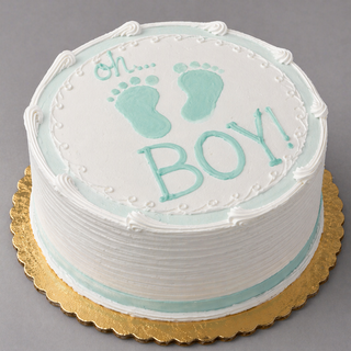 The “Foot Prints” cake is a round white custom cake with blue icing, two footprints, and “oh… BOY!” on top, set on a gold cake board—perfect for baby showers.