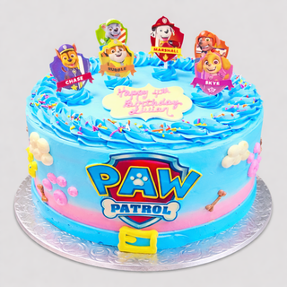 A blue and pink birthday cake decorated with Paw Patrol Toppers, colorful sprinkles, paw prints, bones, and "Happy 4th Birthday Ethan" on top. Perfect for kids' birthdays and PAW Patrol fans.