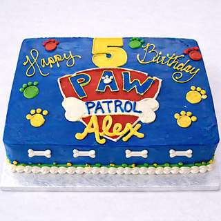 The Paw Patrol Drawn cake is a rectangular blue custom cake with a Paw Patrol shield, colorful paw prints, "Happy 5th Birthday Alex," dog bones, and white frosting trim—perfect for any PAW Patrol fan’s celebration.