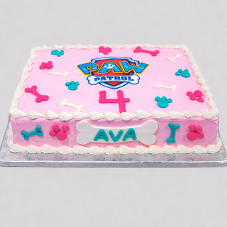 Paw Patrol Prints: Rectangular pink cake with white icing, colorful dog bone and paw decorations, a large blue logo, pink number 4, and “AVA” on a bone plaque—ideal as a custom kids birthday cake.