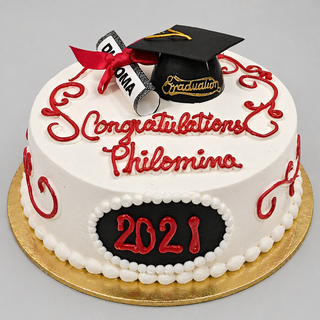 Celebrate with our Diploma Year cake: a round white cake with red icing, "Congratulations Philomina," black grad cap and diploma decorations, plus “2021” in red on a black plaque—a perfect graduation centerpiece.