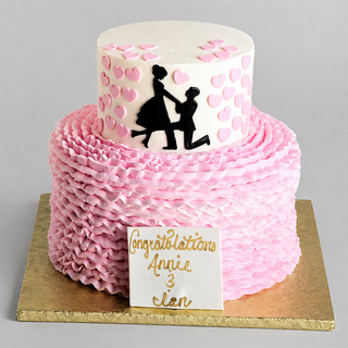 The "Propose Tier" is a two-tiered pink ruffled engagement cake featuring a proposal silhouette, pink hearts, and a “Congratulations Annie & Ian” plaque in gold lettering on the board.