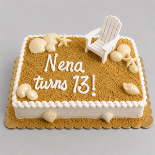 A rectangular "Sand Chair" birthday cake with sandy brown frosting, white icing shells, a white fondant beach chair, and the message "Nena turns 13!" on top, featuring a nautical beach theme.